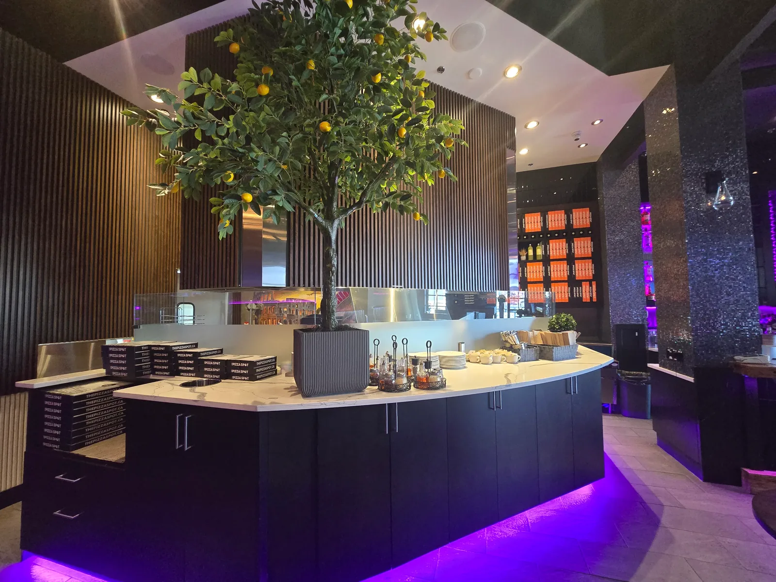 Open pizza kitchen and takeout counter stacked with THE PIZZA SPOT boxes at our West Edmonton Mall location